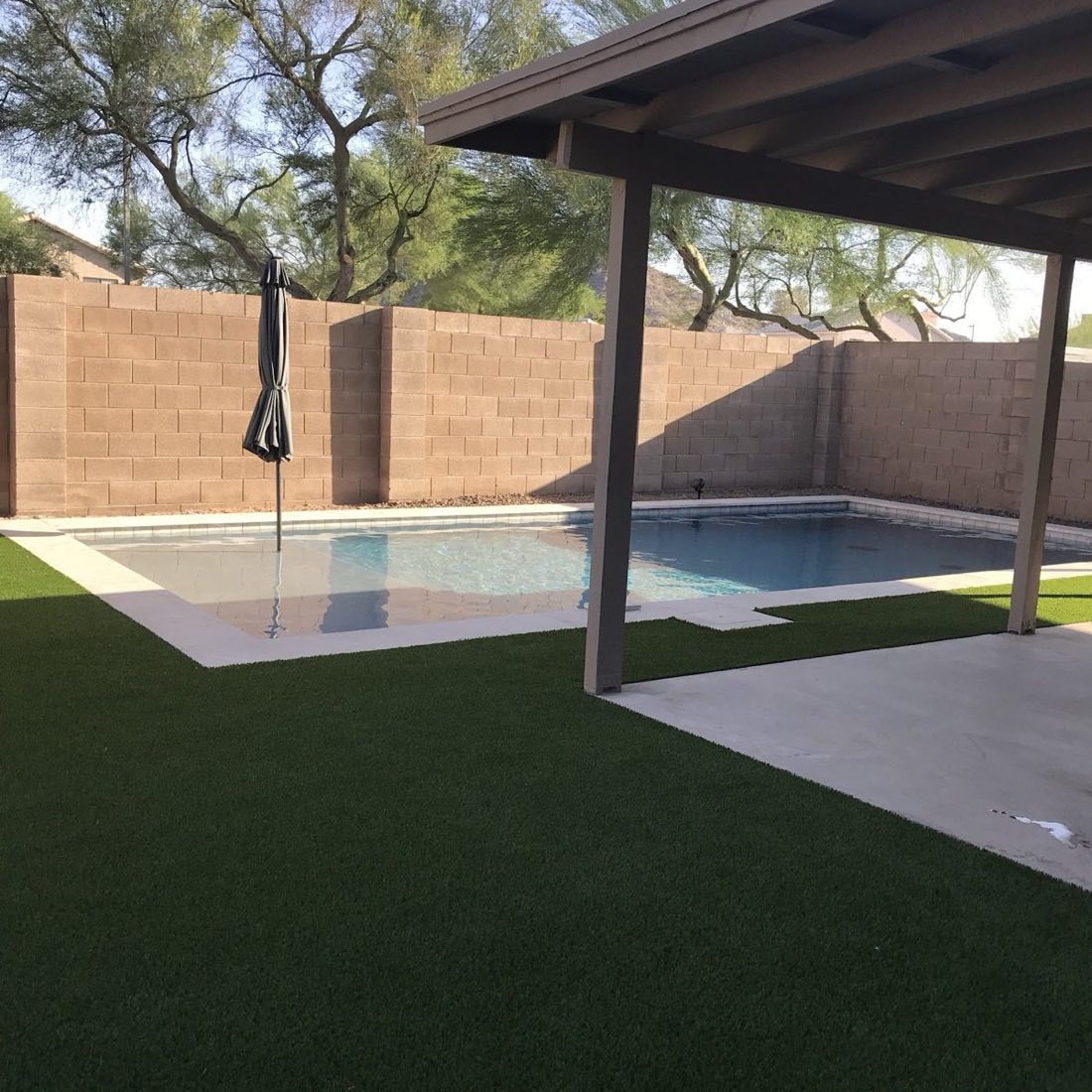 Modern rectangular pool with white tile kept spotless in Phoenix Arizona