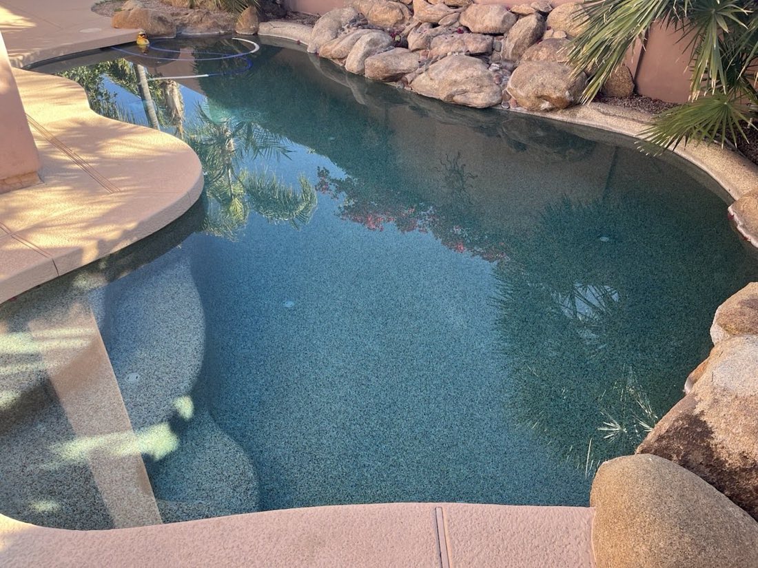 Dark pebble finish pool with clean waterline in a Phoenix backyard